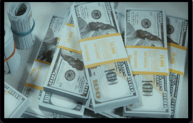 The image shows several stacks of U.S. $100 bills wrapped in yellow bands indicating they are in $10,000 bundles